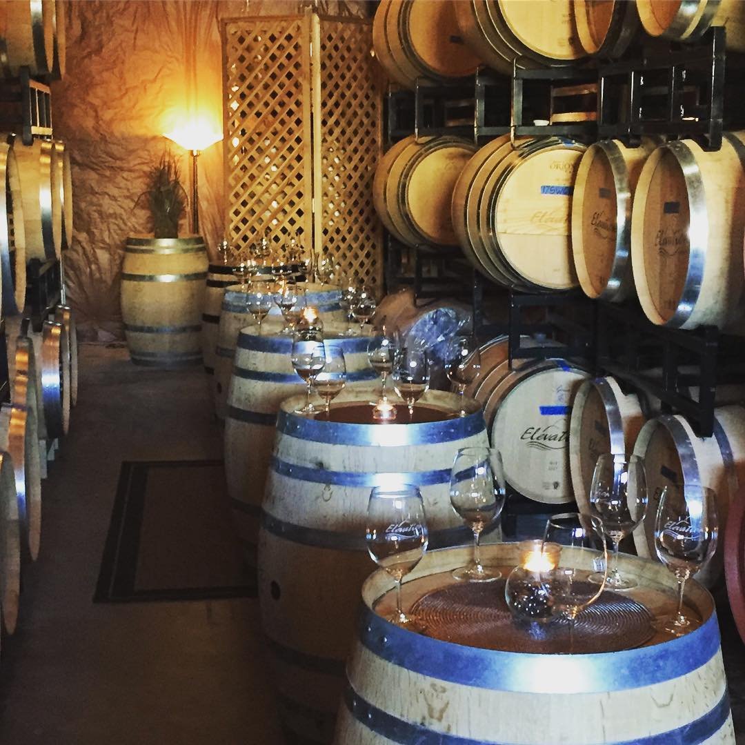 Barrels of wine and wine glasses inside of Elevation Cellars near Bothell, WA.