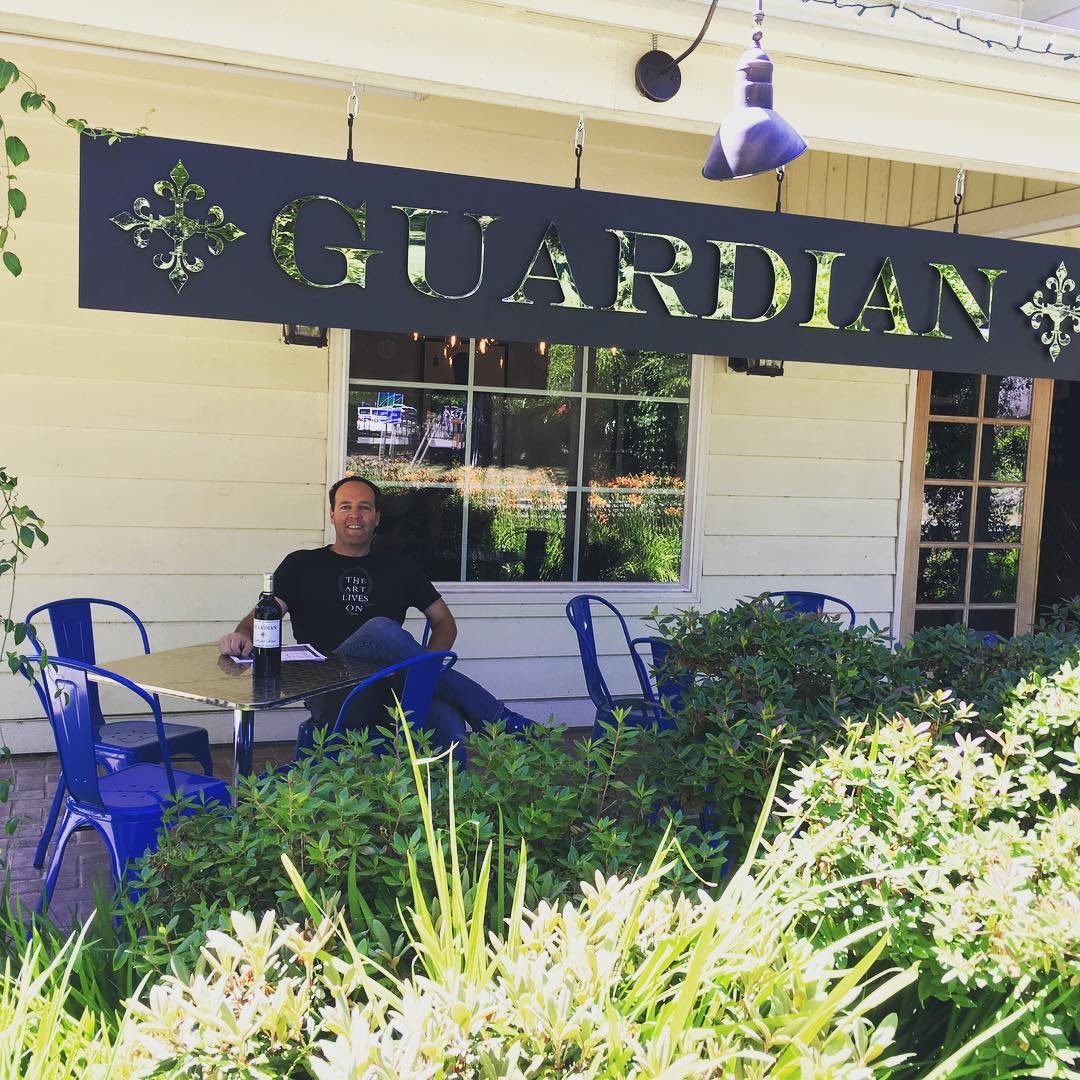Man sitting on the porch outside of Guardian Cellars near Bothell, Washington.