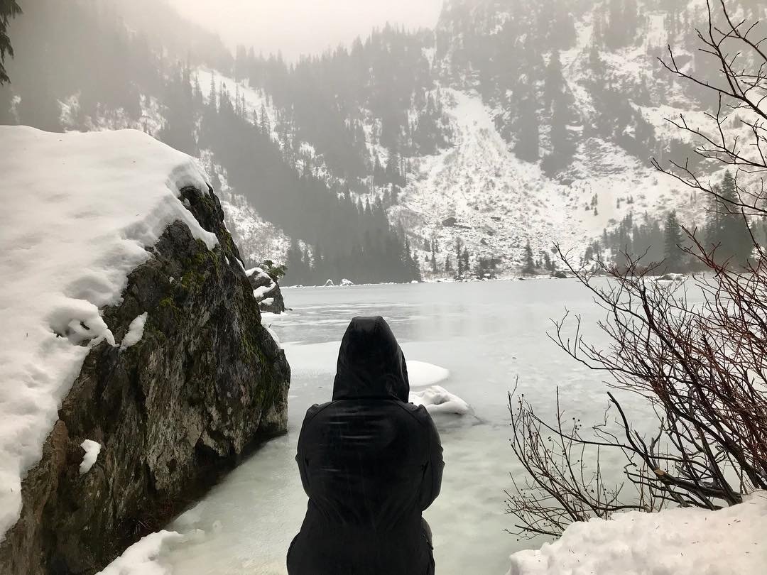 Person looking out on the snowy, frozen Heather Lake near Bothell, Washington.