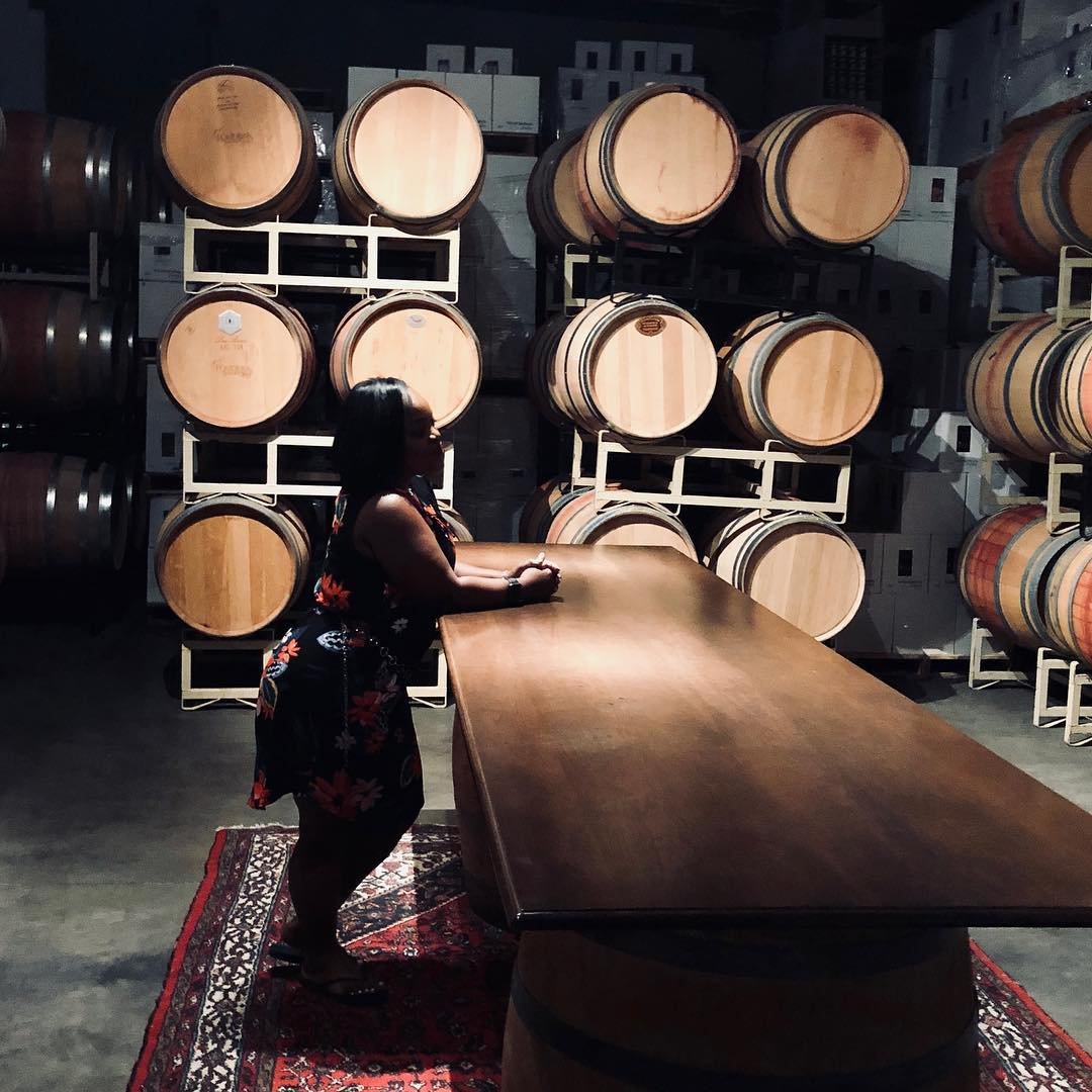 Woman admiring the barrels of wine inside of Pondera Winery near Bothell, WA.