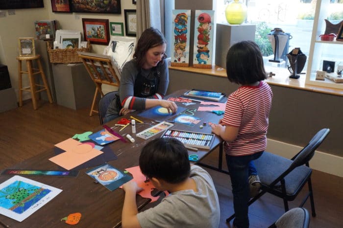Tsuga Fine Arts & Framing's Hannah Waters teaching children in an art class. 