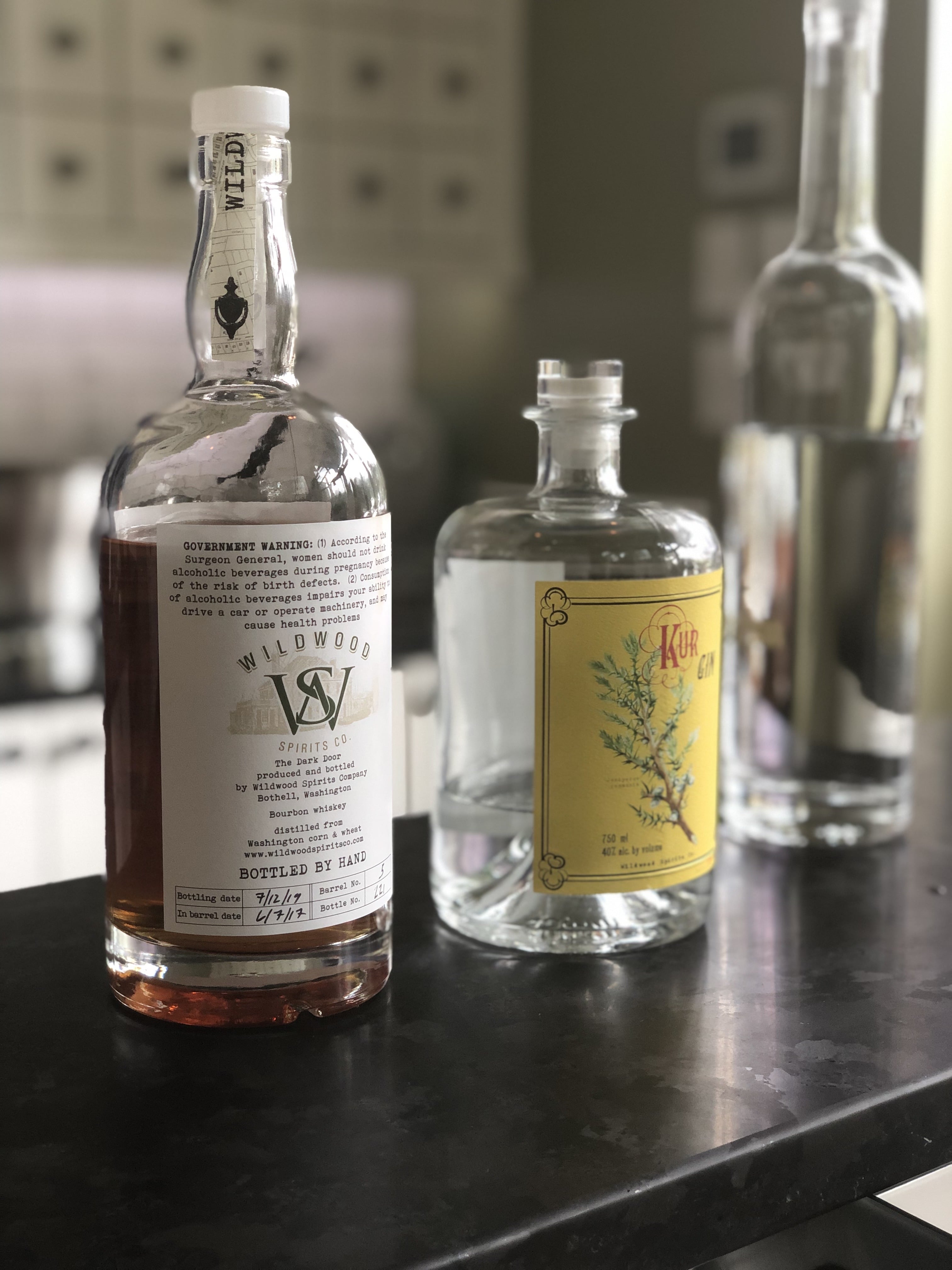 Wildwood Spirits Co apothecary style tasting room, bourbon and gin on counter.
